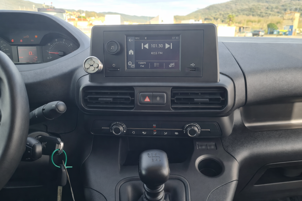Detalle del salpicadero de Peugeot Partner con pantalla multimedia y cambio manual en cabina profesional