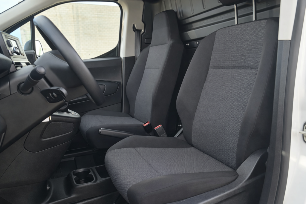 Interior de Peugeot Partner de segunda mano con asientos delanteros en tela y cabina profesional lista para trabajar