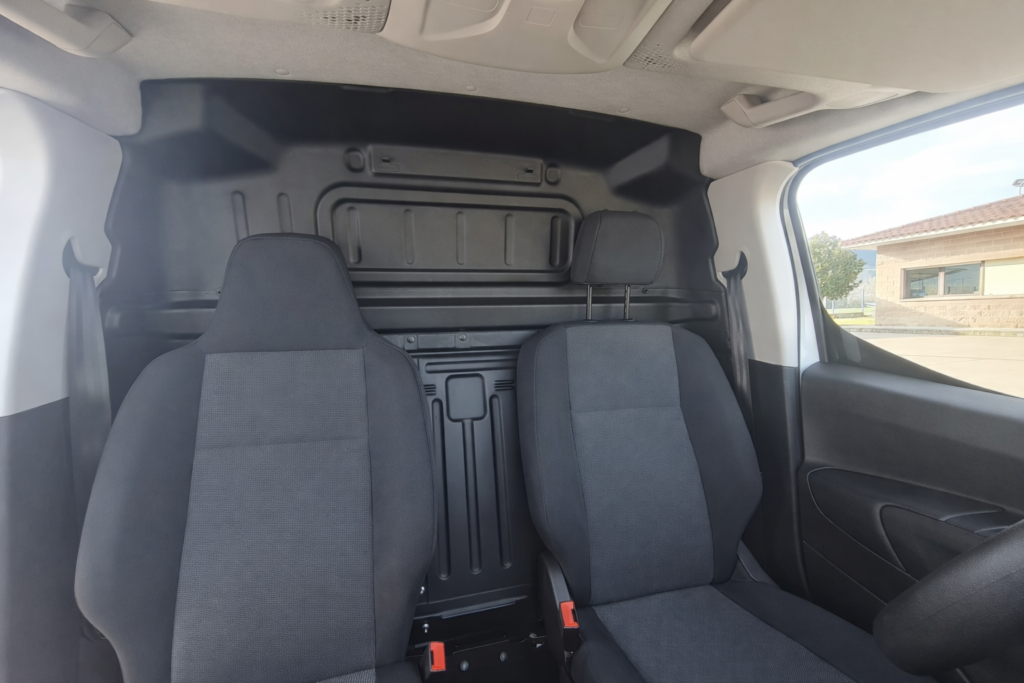 Interior de Peugeot Partner de segunda mano con separador de carga y asientos delanteros en cabina profesional FurgoPro