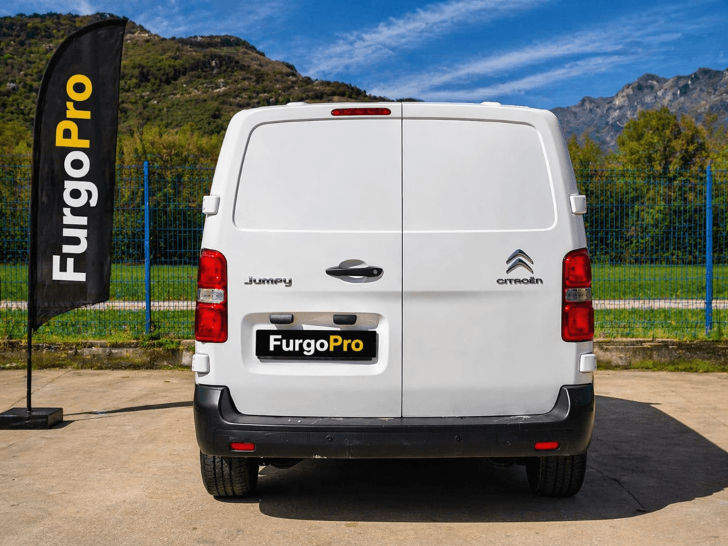 furgoneta citroen jumpy furgon 3 plazas blanca segunda mano vista trasera centrada con fondo profesional furgo pro bandera negra y placa furgo pro