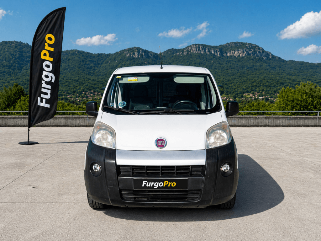Fiat Fiorino 2016 furgon frontal blanca segunda mano en Girona con fondo montañas Garrotxa y branding FurgoPro lista para trabajar