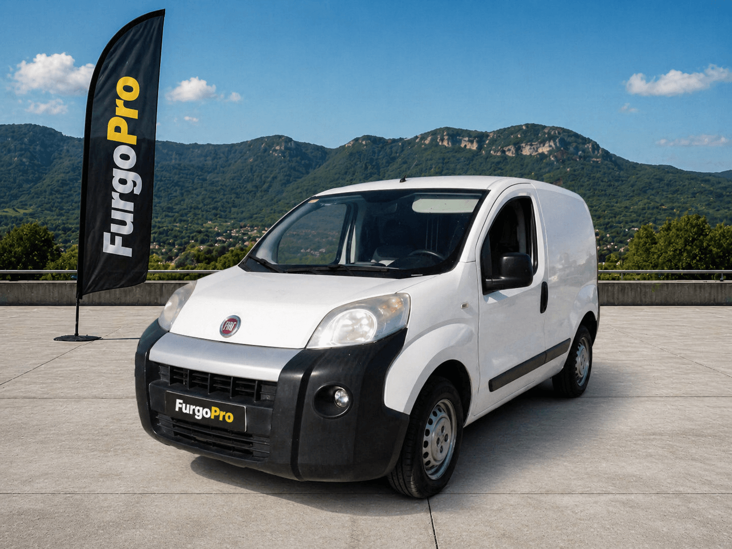 Fiat Fiorino 2016 furgon blanca segunda mano en Girona con fondo montañas Garrotxa y diseño profesional FurgoPro lista para trabajar
