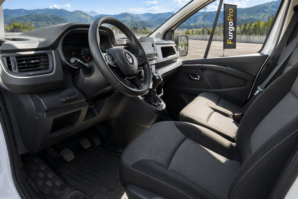 interior renault trafic 9 plazas segunda mano puesto de conductor limpio y profesional con vista exterior y bandera furgopro lista para trabajar