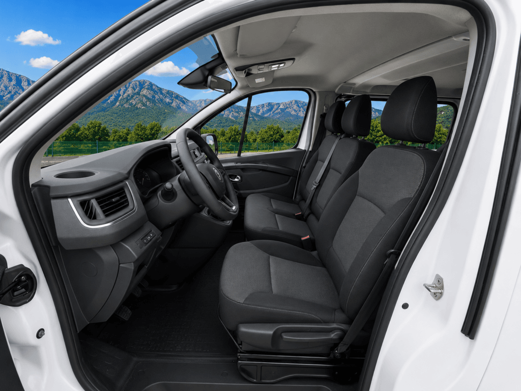 Interior delantero Renault Trafic de segunda mano con asientos negros y paisaje premium FurgoPro visible a través de los cristales.