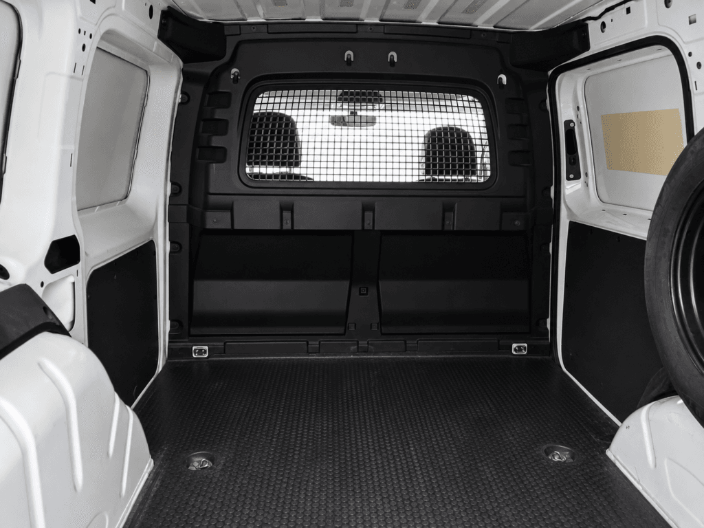 Zona de carga trasera de Volkswagen Caddy de segunda mano completamente limpia, con suelo protegido, mampara separadora metálica y amplio espacio para transporte profesional.