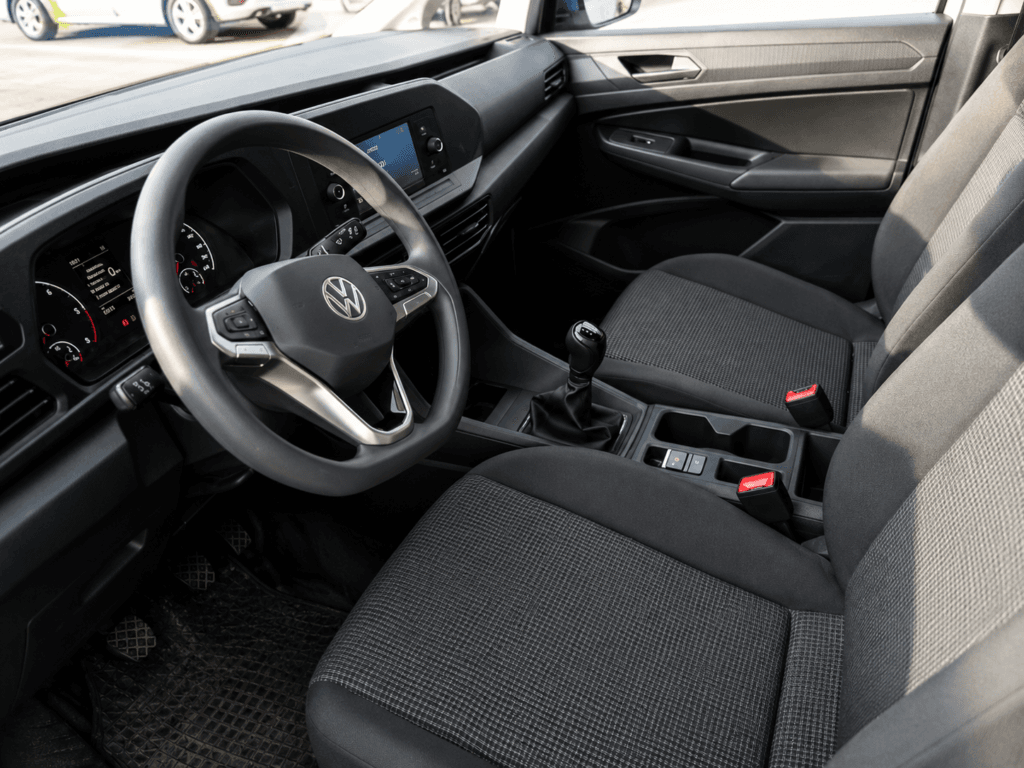 Interior delantero del nuevo modelo de Volkswagen Caddy de segunda mano con volante multifunción, pantalla central, cambio manual y asientos de tela en excelente estado.
